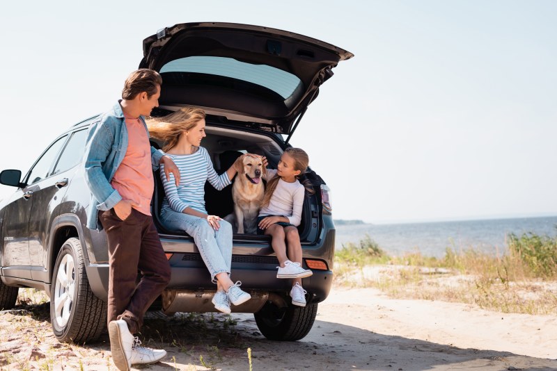 Familie mit Hund und Auto