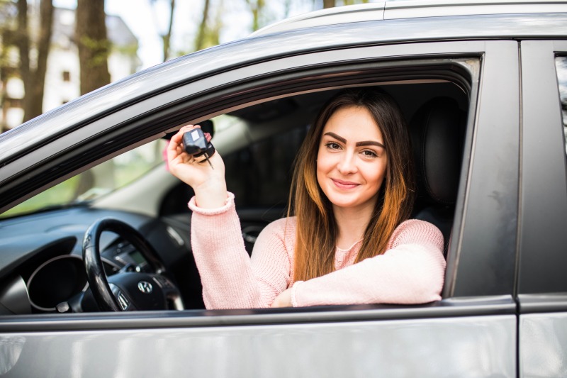 Frau im Auto mit Autoschlüssel